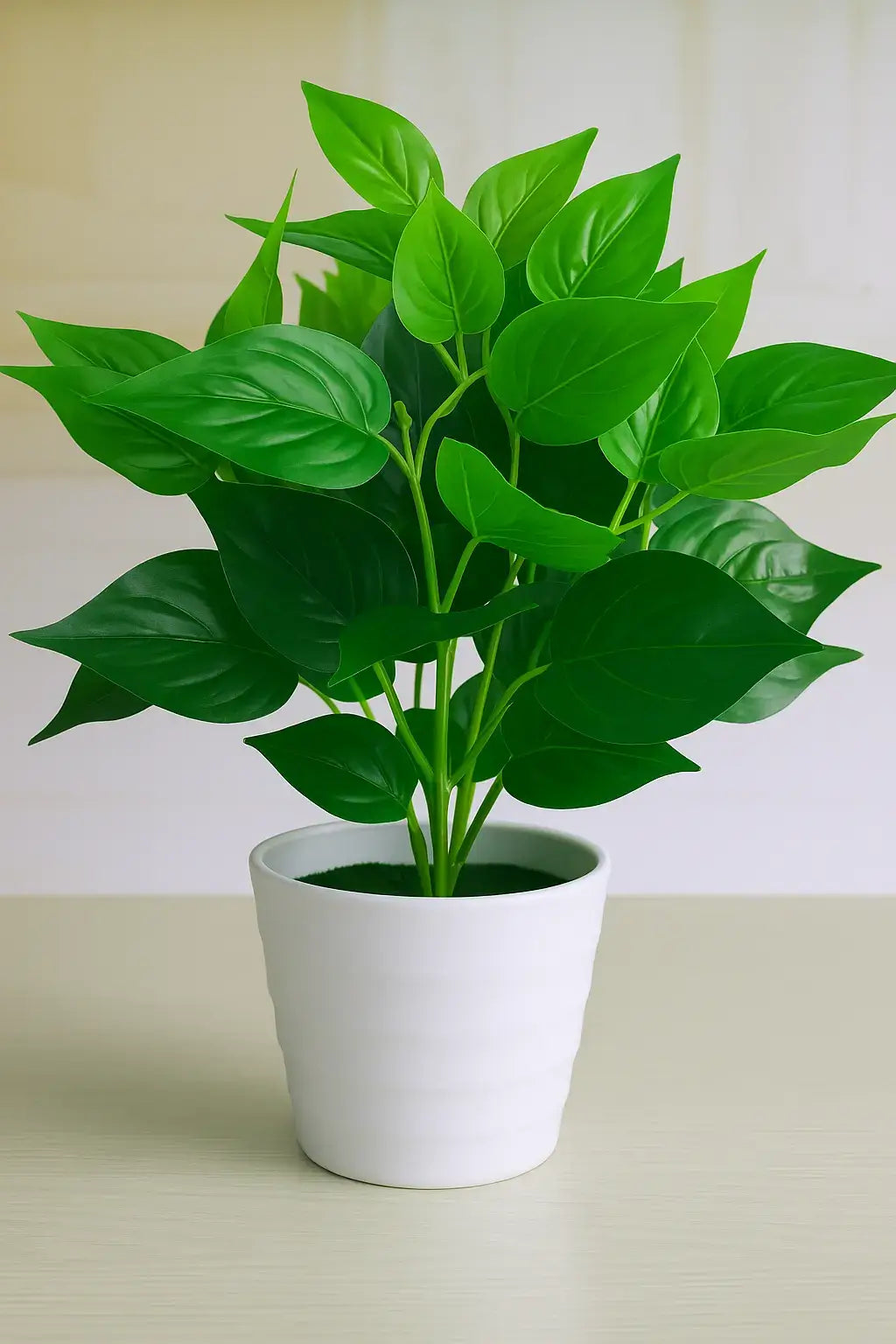 Planta artificial com folhas verdes vibrantes em vaso de cerâmica branca, ideal para decoração de ambientes internos.