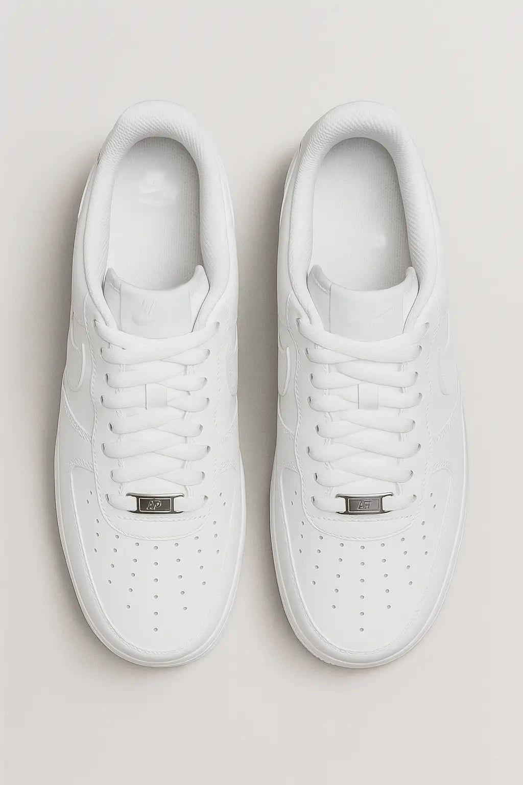 Par de tênis NK branco estilo Air Force em vista superior, com perfurações no cabedal, cadarço branco e etiqueta metálica.