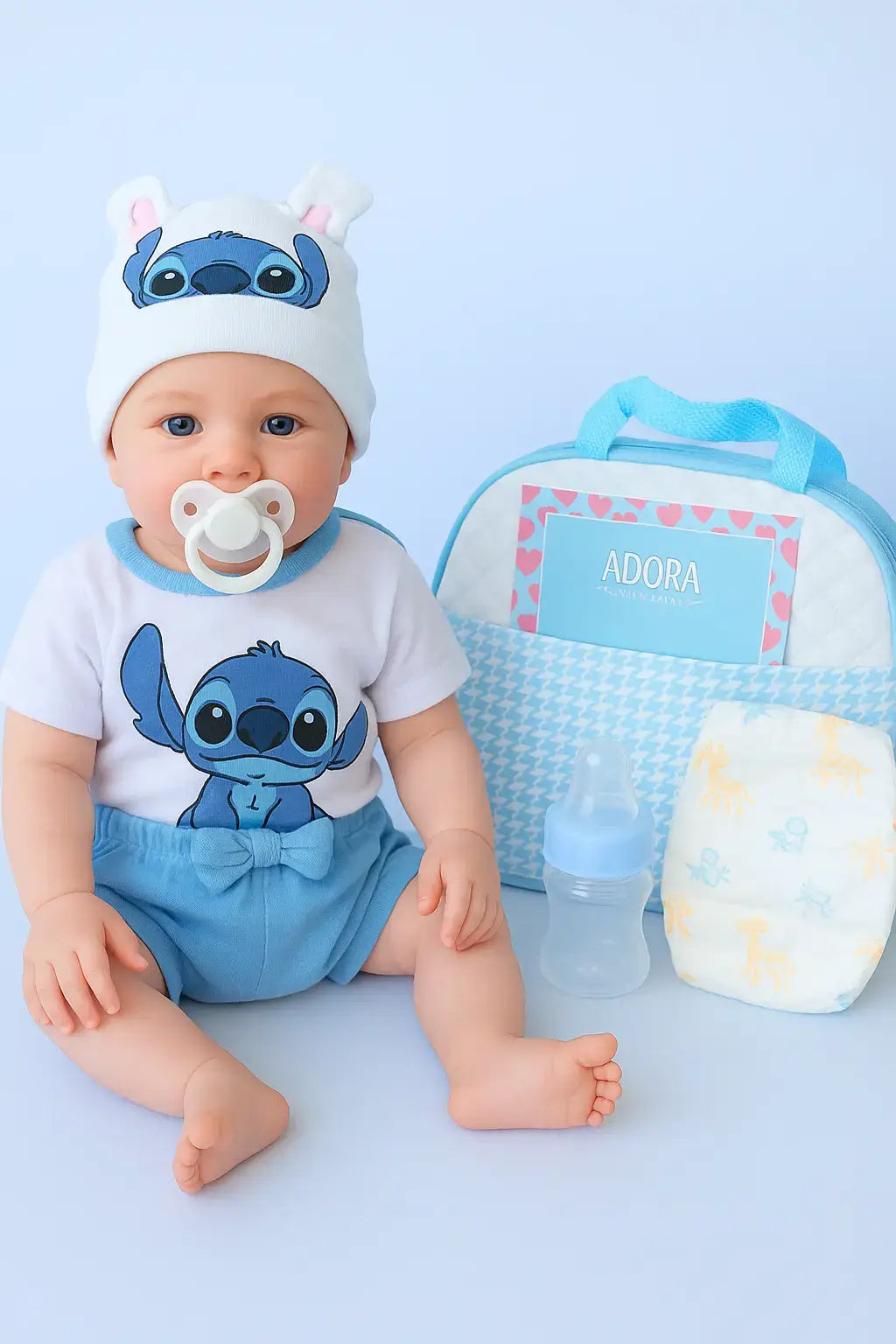 Boneco bebê reborn realista com chupeta, roupa azul do Stitch, bolsa maternidade e mamadeira, ideal para presentes e brincadeiras educativas.